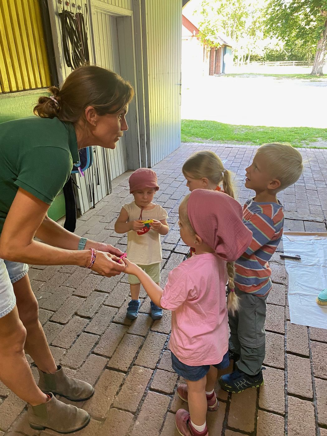 Die Reitpädagogin gibt den Kindern etwas in die Hand